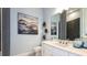 Modern bathroom with white vanity, sleek fixtures, and contemporary artwork creating a spa-like retreat at 4210 Barbuda Ln, Kissimmee, FL 34758