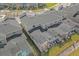 Aerial view of backyard pools, screened in patios, and modern townhomes with gray roofs at 4375 Scene Ln, Kissimmee, FL 34746
