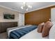 Modern bedroom with a dark accent wall, stylish light fixture, and neutral decor at 4375 Scene Ln, Kissimmee, FL 34746