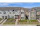 Modern townhouse with a red door, stone accents, and well-maintained landscaping at 4375 Scene Ln, Kissimmee, FL 34746