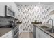 Beautiful kitchen boasting a stylish floral accent wall and stainless steel appliances at 4375 Scene Ln, Kissimmee, FL 34746