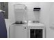 Bright laundry room with modern white washer and dryer, plus overhead storage shelf at 4375 Scene Ln, Kissimmee, FL 34746