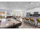 Open-concept living area featuring a kitchen, bar seating, and an air hockey table for entertainment at 4375 Scene Ln, Kissimmee, FL 34746