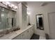 A bright bathroom featuring double sinks, quartz countertops, vanity with mirrors, and modern lighting fixtures at 4412 Conroy Club Dr, Orlando, FL 32835