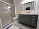 Bathroom featuring a modern vanity with a quartz countertop, chrome fixtures, and a glass-enclosed shower with a mosaic accent wall at 4412 Conroy Club Dr, Orlando, FL 32835