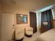 Bedroom showcasing cozy sitting area, complemented by elegant bedside table and lamp at 4412 Conroy Club Dr, Orlando, FL 32835