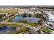 Aerial view showcases community, a lake with fountain, and roads lined with trees at 4608 Atwood Dr, Orlando, FL 32828