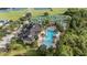 Aerial view of a community pool and clubhouse surrounded by lush greenery and tennis courts at 4608 Atwood Dr, Orlando, FL 32828
