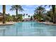 Expansive community pool featuring a waterfall feature, poolside seating and shade at 4608 Atwood Dr, Orlando, FL 32828