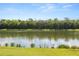 Scenic view of a calm pond surrounded by lush greenery and mature trees at 4608 Atwood Dr, Orlando, FL 32828