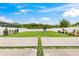Expansive backyard featuring a well-manicured lawn, white fence, and a playset for outdoor enjoyment at 4783 Riverwalk Dr, St Cloud, FL 34771