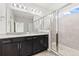 Bathroom with granite countertop, dual sinks, and glass shower enclosure at 4783 Riverwalk Dr, St Cloud, FL 34771