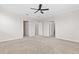 An empty room with carpet, a ceiling fan, and multiple entry doors at 4783 Riverwalk Dr, St Cloud, FL 34771