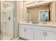 Bathroom featuring double sinks with white cabinets, a framed mirror, and a glass-door shower at 531 Wayland Dr, Haines City, FL 33844