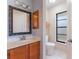 Bathroom vanity featuring decorative mirror and a nearby toilet and window at 622 Tomlinson Ter, Lake Mary, FL 32746
