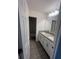 Bathroom with double sinks, white cabinets, gray tile floors, and shower-tub combination at 7116 Cherry Pasture Rd, Groveland, FL 34736