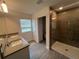 Bright bathroom featuring a double sink vanity, gray tile floor, and a glass-enclosed shower at 7116 Cherry Pasture Rd, Groveland, FL 34736