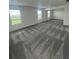 Large bedroom with plush carpeting, three windows, and natural light, perfect for relaxation at 7116 Cherry Pasture Rd, Groveland, FL 34736