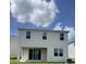Exterior of a two-story home featuring a patio and sliding glass door leading to the backyard at 7116 Cherry Pasture Rd, Groveland, FL 34736