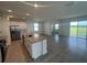 Open-concept kitchen boasts an island, stainless steel appliances, and tile flooring flowing into the living space at 7116 Cherry Pasture Rd, Groveland, FL 34736