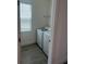 Convenient laundry room features modern machines, tile flooring, and natural light from a window at 7116 Cherry Pasture Rd, Groveland, FL 34736