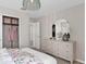 Bright bedroom featuring a patterned dresser, closet with clothes, and decorative light fixture at 7274 Summer Ivy Aly, Orlando, FL 32829