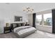 Beautifully staged bedroom with a large bed, modern chandelier, and natural light from two windows at 7274 Summer Ivy Aly, Orlando, FL 32829