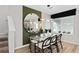 Bright dining room features a glass table, modern lighting fixture, and a decorative round mirror at 7274 Summer Ivy Aly, Orlando, FL 32829