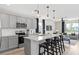 Modern kitchen with stainless steel appliances, quartz countertops, and an island with bar seating at 7274 Summer Ivy Aly, Orlando, FL 32829
