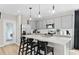 Well-lit kitchen boasts stainless appliances, sleek gray cabinets, quartz countertops, and stylish pendant lighting at 7274 Summer Ivy Aly, Orlando, FL 32829