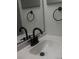 Close-up of white bathroom sink featuring black faucet and black bath accessories at 7606 Pissarro Dr # 14206, Orlando, FL 32819