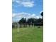 Community area featuring a pier, picnic table, and lush green space under a partly cloudy blue sky at 7606 Pissarro Dr # 14206, Orlando, FL 32819