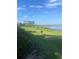 Beautiful lakeside community area with BBQ, picnic table and lush green space under a blue sky at 7606 Pissarro Dr # 14206, Orlando, FL 32819