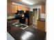 Kitchen with stainless steel appliances, dark countertop, and wood cabinets at 7606 Pissarro Dr # 14206, Orlando, FL 32819