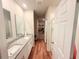 Bright bathroom featuring double vanities, wood-look tile floors, and an adjacent walk-in closet at 877 Rivers Crossings St, Clermont, FL 34714