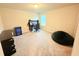 Spacious bedroom with light carpet and a window, featuring a computer, desk, and gaming chair at 877 Rivers Crossings St, Clermont, FL 34714