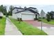 Two-story home with a white two car garage, gray roof, and a brick paver driveway at 877 Rivers Crossings St, Clermont, FL 34714