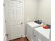 Functional laundry area with white appliances, a door, and tile flooring at 877 Rivers Crossings St, Clermont, FL 34714