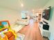 Open-concept living room with wood-look floors that leads to the kitchen at 877 Rivers Crossings St, Clermont, FL 34714