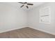 Empty bedroom featuring a ceiling fan, a window with natural light and wood-look tile flooring at 886 Sherbourne Cir, Lake Mary, FL 32746