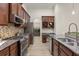 Kitchen with stainless steel appliances and tile backsplash view into the laundry room at 886 Sherbourne Cir, Lake Mary, FL 32746
