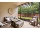 Screened in outdoor living space with comfortable seating and view of the backyard at 886 Sherbourne Cir, Lake Mary, FL 32746