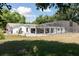 Expansive backyard with white home, screened-in pool, and mature trees for outdoor enjoyment at 949 Shadow Oaks Rd, Kissimmee, FL 34744