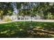 Lawn view of home featuring screened pool with greenery at 949 Shadow Oaks Rd, Kissimmee, FL 34744