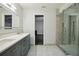 Bathroom featuring a gray vanity with double sinks and a glass-enclosed shower at 949 Shadow Oaks Rd, Kissimmee, FL 34744