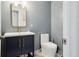 Powder room featuring a blue vanity, gold fixtures, and a toilet at 949 Shadow Oaks Rd, Kissimmee, FL 34744