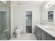 Bathroom with a gray vanity, double sinks, and a glass-enclosed shower at 949 Shadow Oaks Rd, Kissimmee, FL 34744