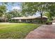 This one-story brick house boasts a metal roof and neatly maintained landscaping at 949 Shadow Oaks Rd, Kissimmee, FL 34744