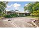 A single story brick home with metal roof and a garden entry at 949 Shadow Oaks Rd, Kissimmee, FL 34744