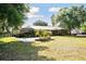 A ranch-style home with a metal roof, expansive lawn, and well-maintained landscaping, offering a tranquil setting at 949 Shadow Oaks Rd, Kissimmee, FL 34744